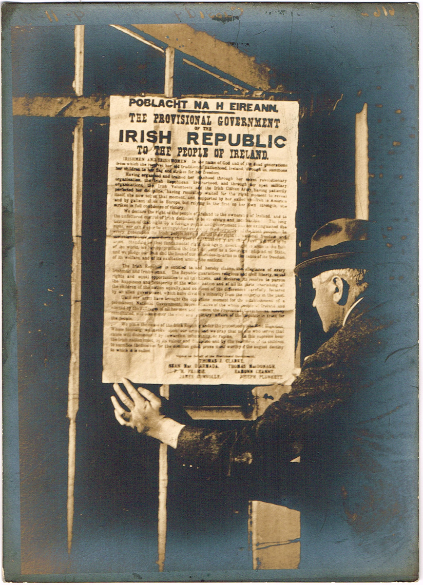1916 Proclamation: an original photograph showing a man affixing the Proclamation of the Irish Republic to a barred gate. at Whyte's Auctions