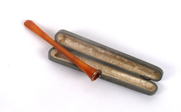 An early 20th century rose-gold mounted amber cigarette holder. at Whyte's Auctions