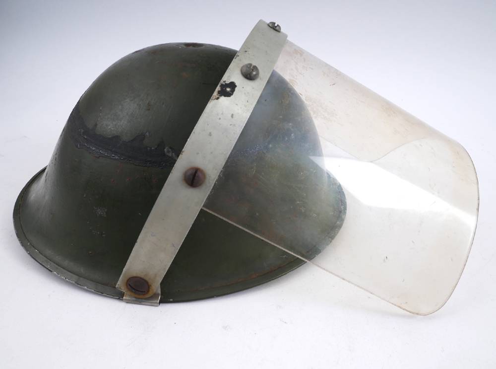 1970 Raglan Street, Falls Curfew, British Army steel helmet with visor. at Whyte's Auctions